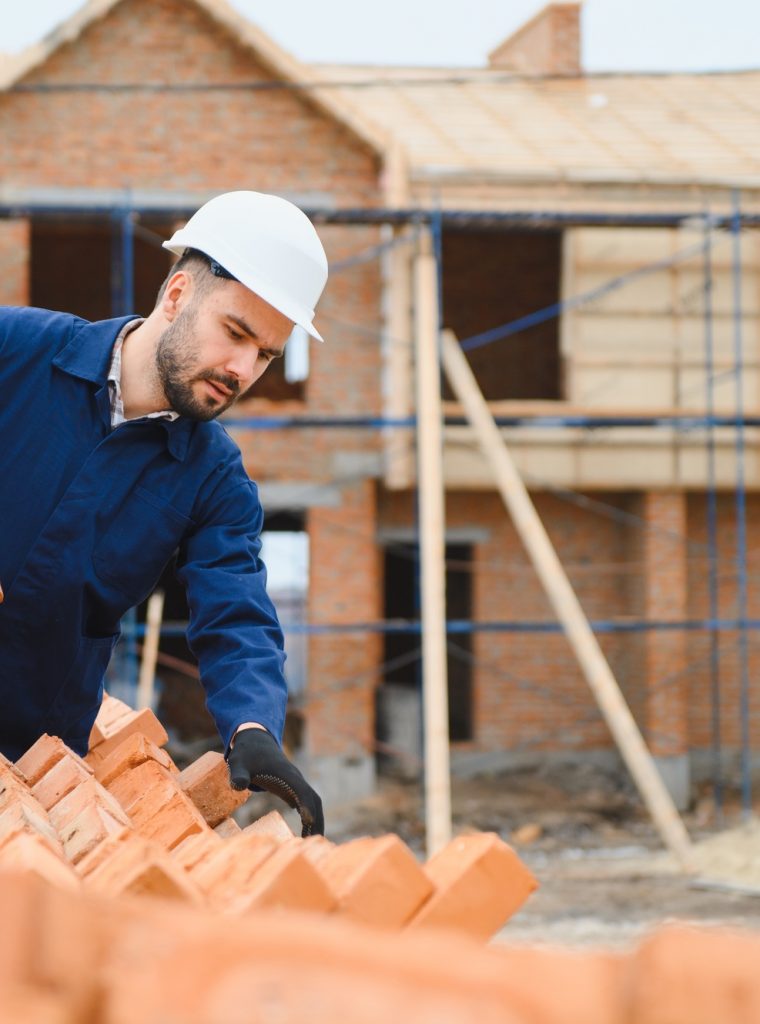 Portrait of a builder in the process of working on a construction site outdoors